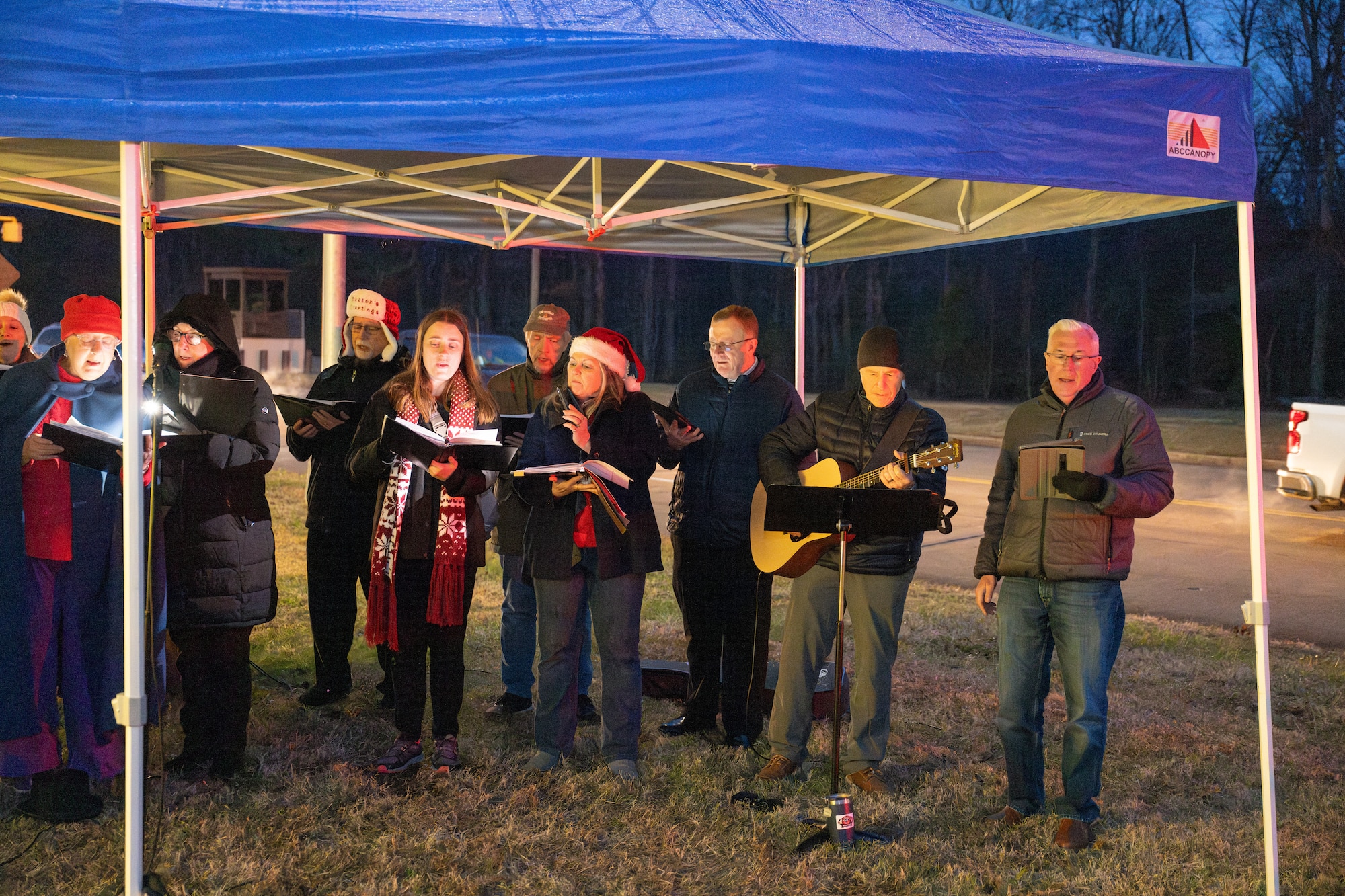 The Tullahoma Civic Choir performs Christmas carols during the Arnold Air Force Base Christmas tree lighting ceremony, Dec. 4, 2025. The tree at Arnold AFB, Tenn., headquarters of AEDC, was purchased in 2023 after installation leadership expressed a desire for a Christmas tree to be displayed at a prominent location on the base. The tree measures 40 feet tall and 22 feet wide. It is decorated with approximately 300 ornaments and is topped with a 5-foot 3D five-point star. (U.S. Air Force photo by Keith Thornburgh)