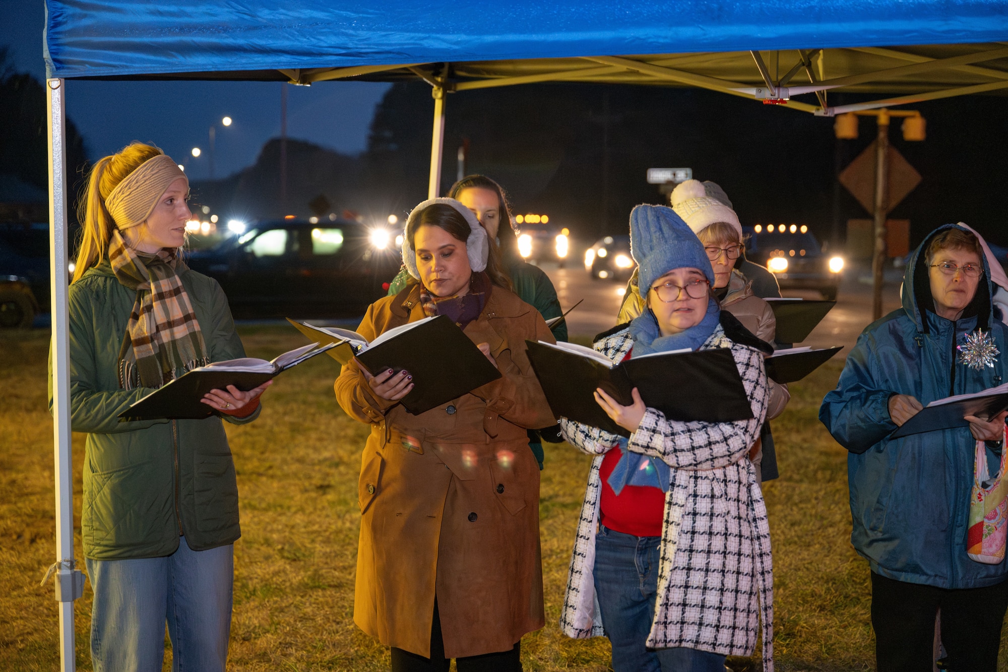 The Tullahoma Civic Choir performs Christmas carols during the Arnold Air Force Base Christmas tree lighting ceremony Dec. 4, 2025. The tree at Arnold AFB, Tenn., headquarters of AEDC, was purchased in 2023 after installation leadership expressed a desire for a Christmas tree to be displayed at a prominent location on the base. The tree measures 40 feet tall and 22 feet wide. It is decorated with approximately 300 ornaments and is topped with a 5-foot 3D five-point star. (U.S. Air Force photo by Keith Thornburgh)