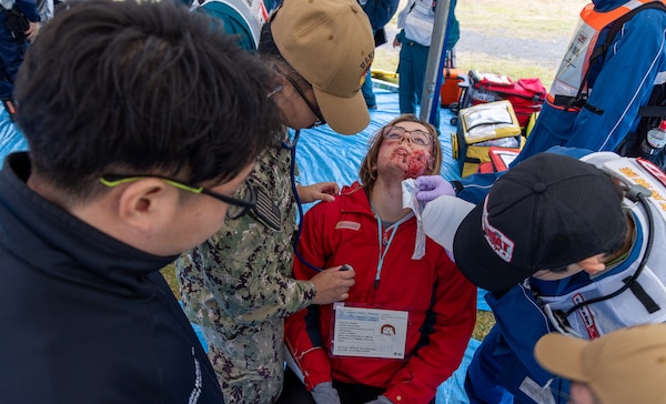 JOGASHIMA PARK, Japan (Nov. 9, 2025) — A U.S. Navy Hospital Corpsman assigned to U.S. Navy Medicine Readiness and Training Command Yokosuka works with Japanese responders to assess and treat a simulated casualty during Big Rescue Kanagawa 2025. The annual exercise is one of Kanagawa Prefecture’s largest disaster-response drills, involving U.S. Naval Hospital Yokosuka, Red Cross Yokosuka and Branch Health Clinic Atsugi personnel working alongside U.S. and Japanese agencies. (U.S. Navy photo by Daniel Taylor/USNMRTC Public Affairs)