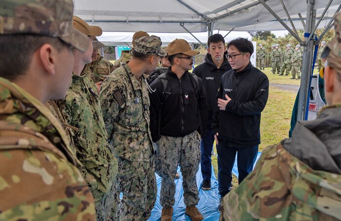 JOGASHIMA PARK, Japan (Nov. 9, 2025) — Doctors Takehiro Mochizuki and Sho Nonoyama, both Japanese Fellows assigned to U.S. Naval Hospital Yokosuka, introduce themselves to their team prior to the start of Big Rescue Kanagawa 2025. The annual exercise is one of Kanagawa Prefecture’s largest disaster-response drills, involving U.S. Naval Hospital Yokosuka, Red Cross Yokosuka and Branch Health Clinic Atsugi personnel working alongside U.S. and Japanese agencies. (U.S. Navy photo by Daniel Taylor/USNMRTC Public Affairs)