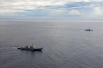 U.S. Navy P-8A Poseidon, assigned to Patrol Squadron (VP) 45, executes a low-altitude flyover as U.S. Navy Arleigh Burke-class guided-missile destroyer USS Rafael Peralta (DDG 115) steams in formation with Philippine Navy Jose Rizal-class frigate BRP Jose Rizal (FF 150) in the South China Sea, Dec. 10.