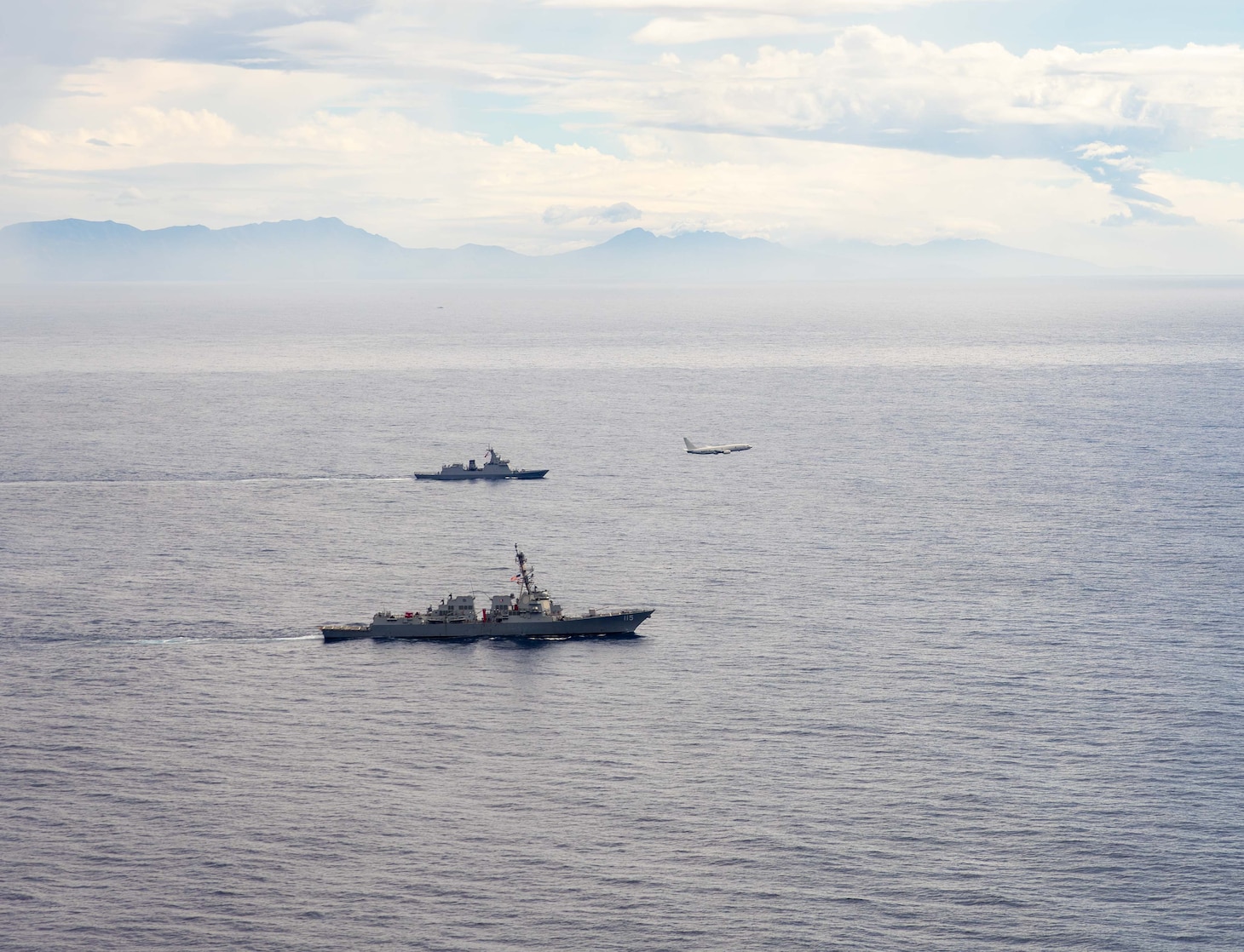 U.S. Navy P-8A Poseidon, assigned to Patrol Squadron (VP) 45, executes a low-altitude flyover as U.S. Navy Arleigh Burke-class guided-missile destroyer USS Rafael Peralta (DDG 115) steams in formation with Philippine Navy Jose Rizal-class frigate BRP Jose Rizal (FF 150) in the South China Sea, Dec. 10.