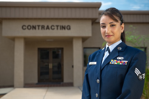 An Airman standing in front of a contracting building.
