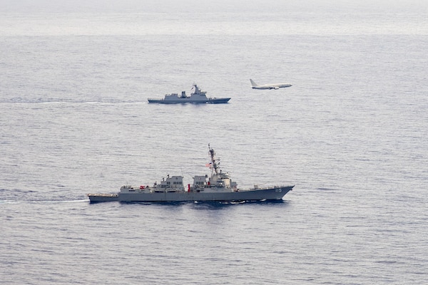 U.S. Navy P-8A Poseidon, assigned to Patrol Squadron (VP) 45, executes a low-altitude flyover as U.S. Navy Arleigh Burke-class guided-missile destroyer USS Rafael Peralta (DDG 115) steams in formation with Philippine Navy Jose Rizal-class frigate BRP Jose Rizal (FF 150) in the South China Sea, Dec. 10.
