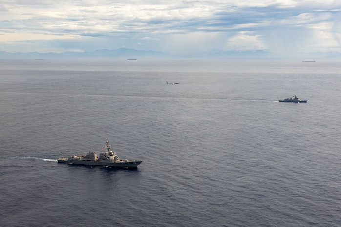 U.S. Navy P-8A Poseidon, assigned to Patrol Squadron (VP) 45, executes a low-altitude flyover as U.S. Navy Arleigh Burke-class guided-missile destroyer USS Rafael Peralta (DDG 115) steams in formation with Philippine Navy Jose Rizal-class frigate BRP Jose Rizal (FF 150) in the South China Sea, Dec. 10.