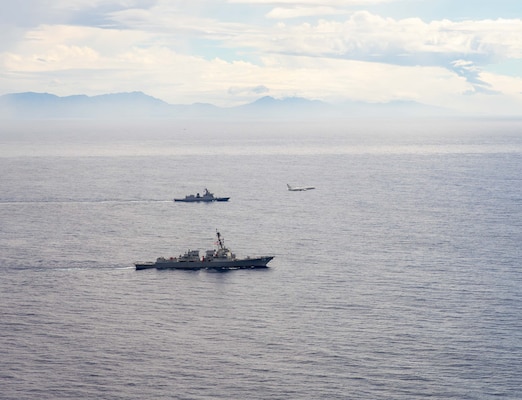 U.S. Navy P-8A Poseidon, assigned to Patrol Squadron (VP) 45, executes a low-altitude flyover as U.S. Navy Arleigh Burke-class guided-missile destroyer USS Rafael Peralta (DDG 115) steams in formation with Philippine Navy Jose Rizal-class frigate BRP Jose Rizal (FF 150) in the South China Sea, Dec. 10.
