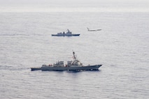 U.S. Navy P-8A Poseidon, assigned to Patrol Squadron (VP) 45, executes a low-altitude flyover as U.S. Navy Arleigh Burke-class guided-missile destroyer USS Rafael Peralta (DDG 115) steams in formation with Philippine Navy Jose Rizal-class frigate BRP Jose Rizal (FF 150) in the South China Sea, Dec. 10.