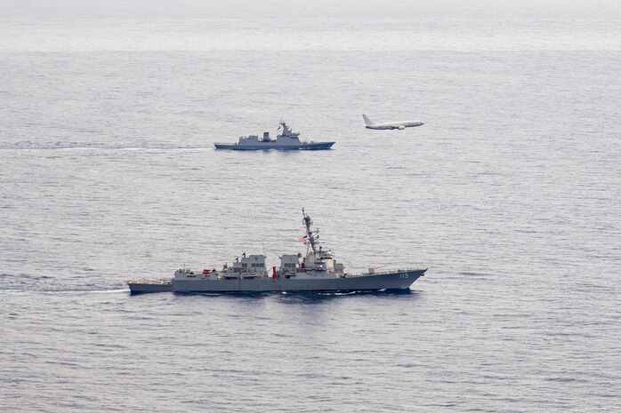 U.S. Navy P-8A Poseidon, assigned to Patrol Squadron (VP) 45, executes a low-altitude flyover as U.S. Navy Arleigh Burke-class guided-missile destroyer USS Rafael Peralta (DDG 115) steams in formation with Philippine Navy Jose Rizal-class frigate BRP Jose Rizal (FF 150) in the South China Sea, Dec. 10.