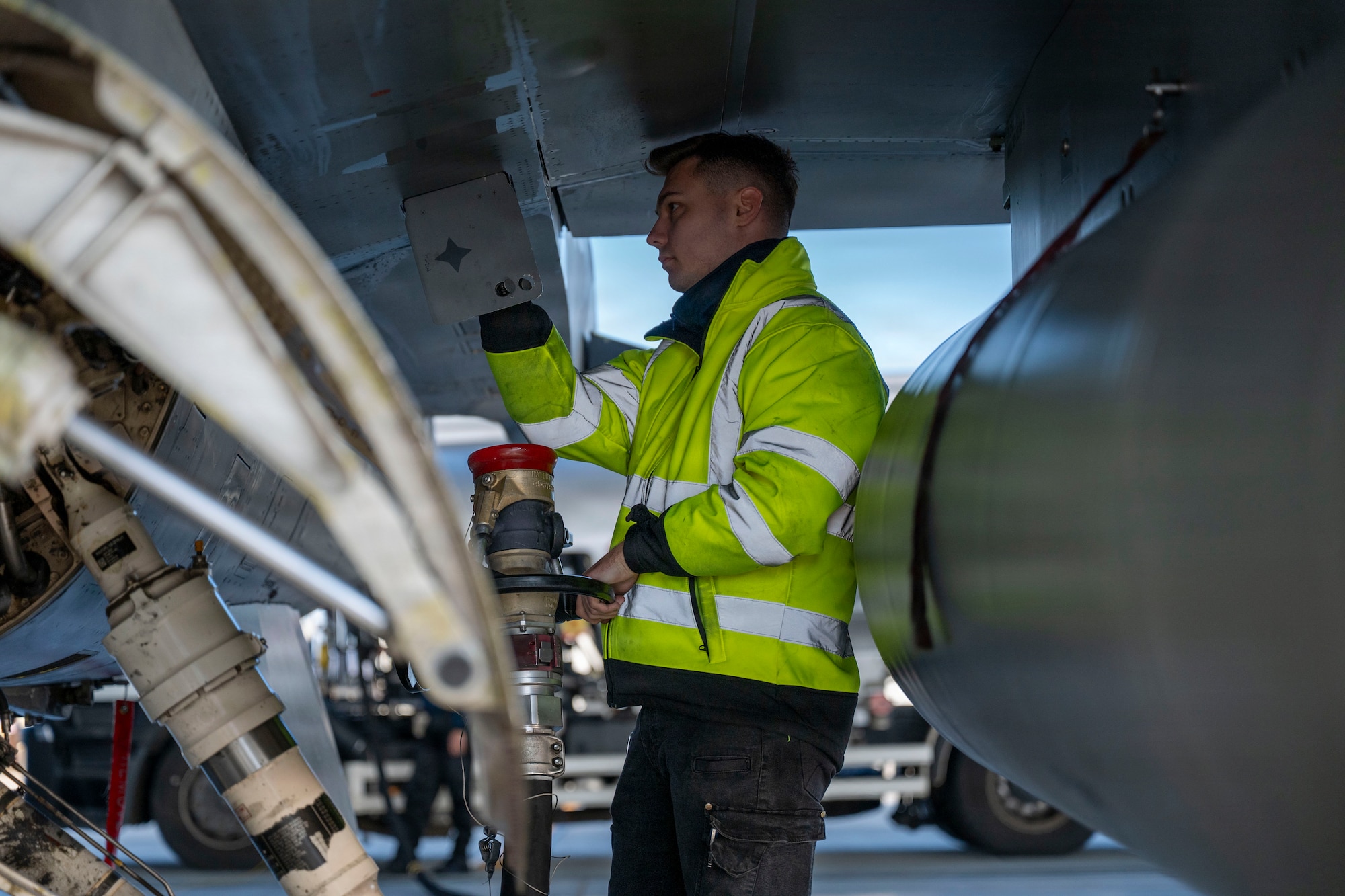 A Romanian Air Force member refuels a U.S. Air Force F-16 Fighting Falcon assigned tothe 555th Fighter Generation Squadron during routine Agile Combat Employment operations at Campia Turzii, Romania