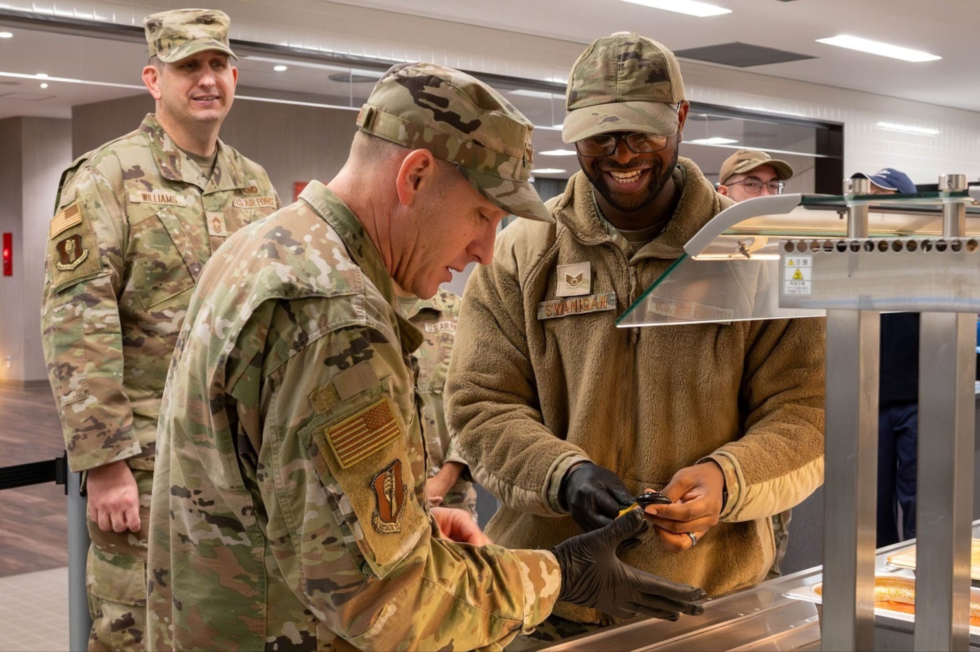 U.S. Air Force Staff Sgt. Kayce Swanigan, 35th Force Support Squadron food service technician, shows Col. Paul Davidson, 35th Fighter Wing commander, how to check sauce temperature at Misawa Air Base, Japan, Dec. 8, 2025. Through thorough Wild Weasel Public Health checks, they protect Team Misawa by keeping food operations safe, compliant and risk-free. (U.S. Air Force photo by Airman 1st Class Jessel Fabara)