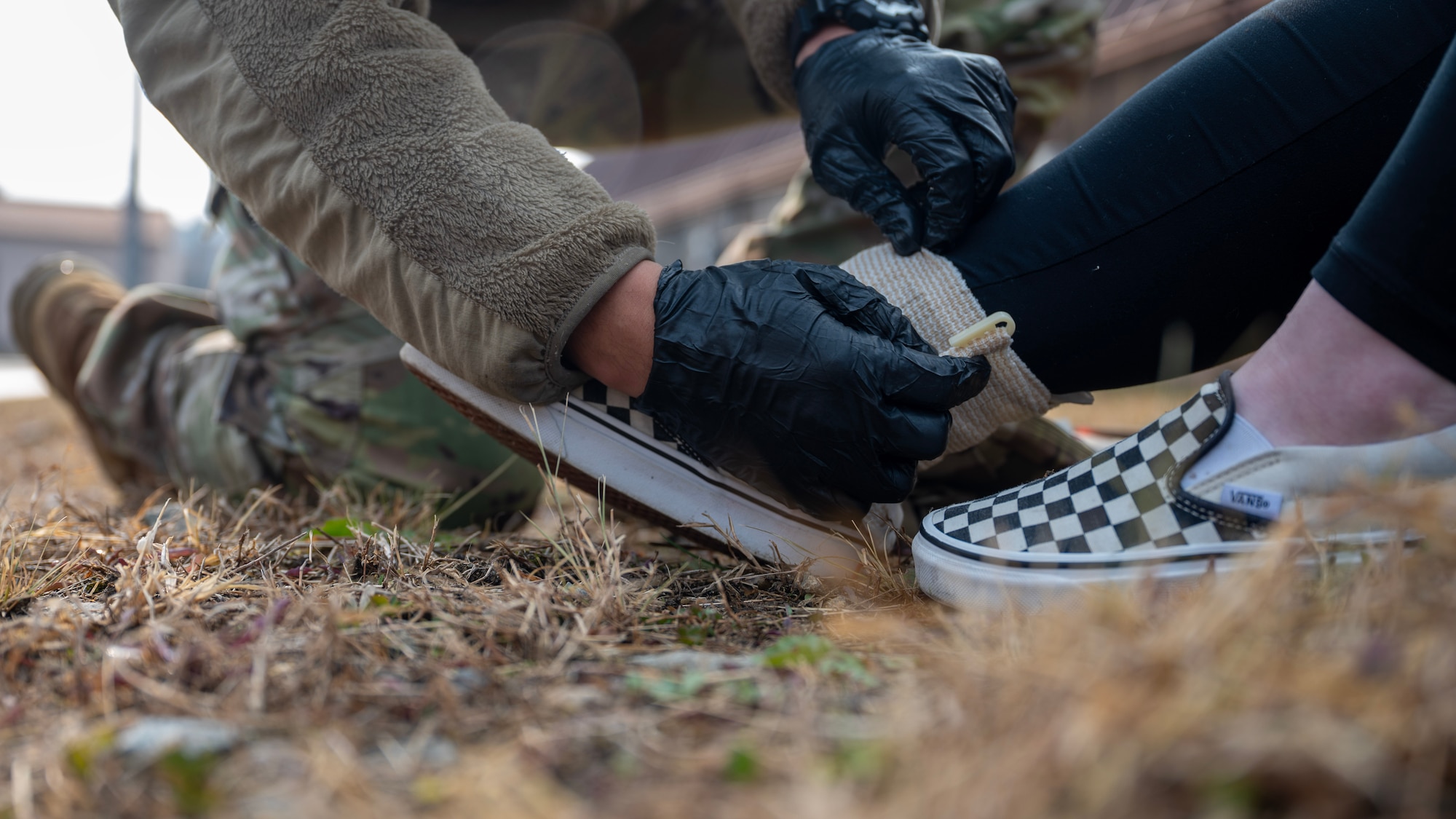 An ankle is wrapped as a part of a Tactical Combat Casualty Care exercise during MUSTANG RODEO 26-1 at Osan Air Base, Republic of Korea, Dec. 10, 2025. MUSTANG RODEO provides regular opportunities for Airmen to rehearse targeted skill sets and bridge the gap between large-scale events, ensuring that critical tasks are performed with speed and precision, even when operating under limited time or simulated operational stress. (U.S. Air Force photo by Staff Sgt. Sarah Williams)