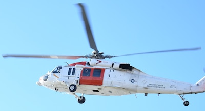 An MH-60S Seahawk helicopter from the Naval Air Station (NAS) Patuxent River "SAR Dogs" unit scans the coastline during a challenging L00A qualification flight. The aircrew was tasked with locating a simulated crash site with no prior location data. This unscripted scenario is a critical component of the qualification process, ensuring the SAR team can effectively respond to distress calls when precise location data is unavailable.