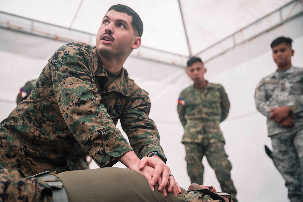 U.S. Navy Hospitalman Second Class Juan Florestorres, assigned to Marine Rotational Force-Southeast Asia, I Marine Expeditionary Force, applies direct pressure on a simulated wound during a tactical combat casualty care subject matter expert exchange as part of exercise Marine Air Support Activity 2025 at Marine Base Camp Rodolfo, Palawan, Philippines, Oct. 13, 2025. TCCC is a training program for non-medical personnel to have knowledge and skills to render life-saving medical aid in the absence of medical personnel in combat scenarios.  MASA 25 is an annual joint Philippine and U.S. military exercise focused on mutual defense, strengthening relationships, and rehearsing emerging aviation concepts. Florestorres is a native of Florida. (U.S. Marine Corps photo by Sgt. Luis Agostini)