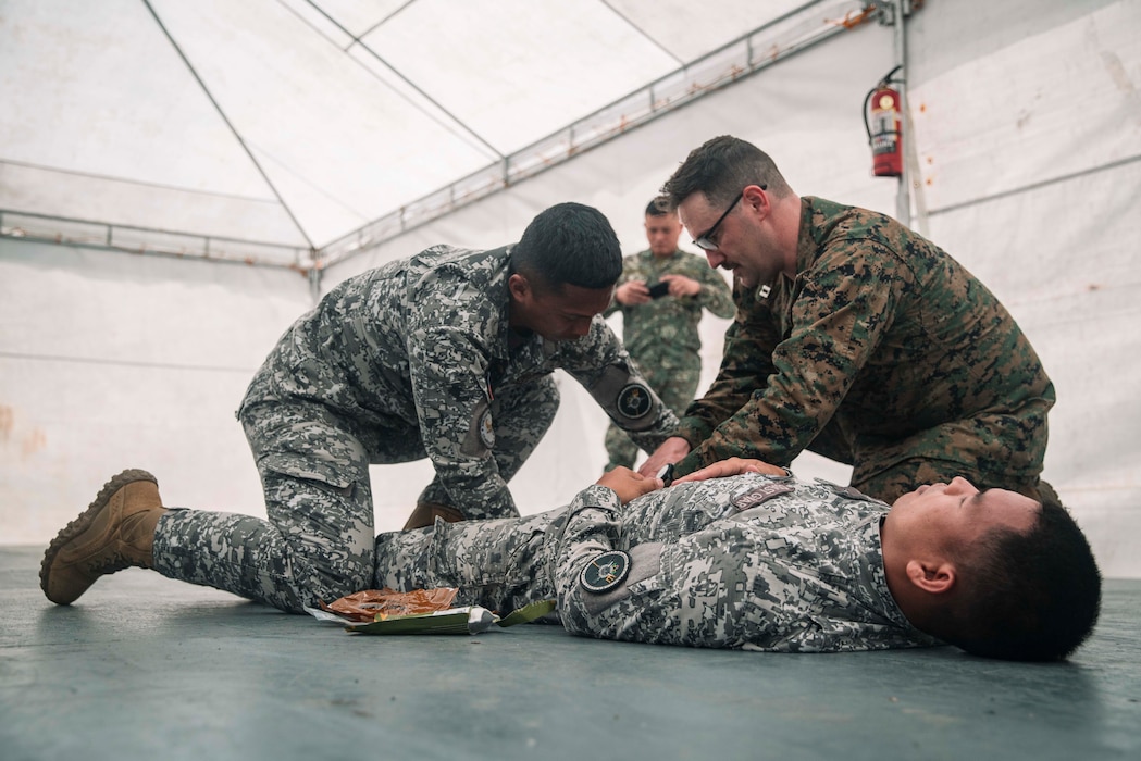U.S. Navy Lt. Terrence Hamilton, right, a medical physician assigned to Marine Rotational Force-Southeast Asia, I Marine Expeditionary Force, and Philippine Coast Guardsmen Seaman Second Class Jerome Devero, apply bandages to a simulated wound during a tactical combat casualty care subject matter expert exchange as part of exercise Marine Air Support Activity 2025 at Marine Base Camp Rodolfo, Palawan, Philippines, Oct. 13, 2025. TCCC is a training program for non-medical personnel to have knowledge and skills to render life-saving medical aid in the absence of medical personnel in combat scenarios.  MASA 25 is an annual joint Philippine and U.S. military exercise focused on mutual defense, strengthening relationships, and rehearsing emerging aviation concepts. Hamilton is a native of Minnesota. (U.S. Marine Corps photo by Sgt. Luis Agostini)