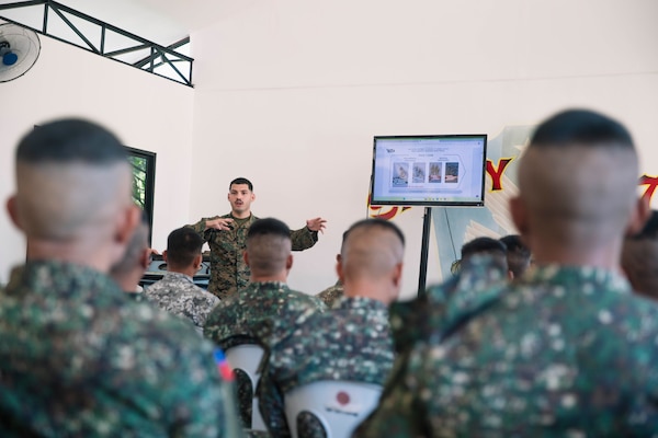 U.S. Navy Hospitalman Second Class Juan Florestorres, assigned to Marine Rotational Force-Southeast Asia, I Marine Expeditionary Force, explains how to provide medical care under fire to MRF-SEA Marines, Philippine Marines assigned to 3rd Marine Brigade and Philippine Coastguardsmen as part of a tactical combat casualty care subject matter expert exchange during exercise Marine Air Support Activity 2025 at Marine Base Camp Rodolfo, Palawan, Philippines, Oct. 13, 2025. TCCC is a training program for non-medical personnel to have knowledge and skills to render life-saving medical aid in the absence of medical personnel in combat scenarios. MASA 25 is an annual joint Philippine and U.S. military exercise focused on mutual defense, strengthening relationships, and rehearsing emerging aviation concepts. Florestorres is a native of Florida. (U.S. Marine Corps photo by Sgt. Luis Agostini)