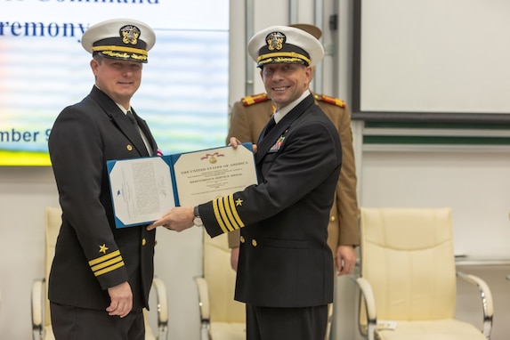 Capt. Jeremy Carlson, Commander of Task Force SIX FOUR, presents Cmdr. Robert Foster with the Meritorious Service Medal following his successful tour as commanding officer of Aegis Ashore Missile Defense System Romania.