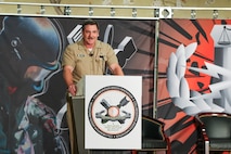 Captain delivers speech to crowd of people at event.