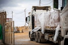 Trucks carrying humanitarian aid are staged at the Zikim Crossing Point on Nov. 25, 2025, in Israel. The United States is working with the international community to facilitate the flow of humanitarian assistance to civilians in Gaza. (U.S. Army photo Staff Sgt. Michael Ito.)