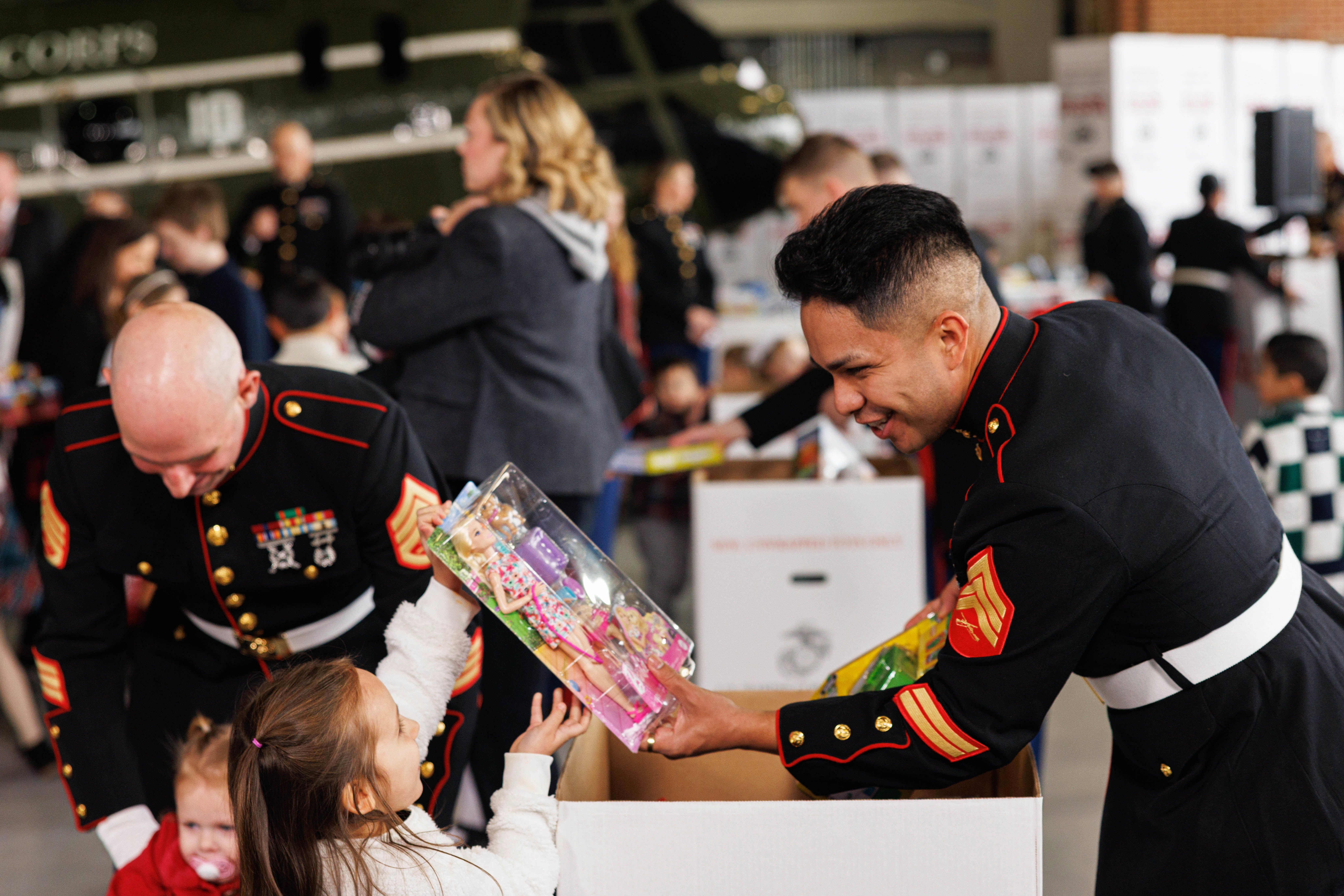 Marines dressed in Christmas-themed costumes pose with Toys for Tots donations.