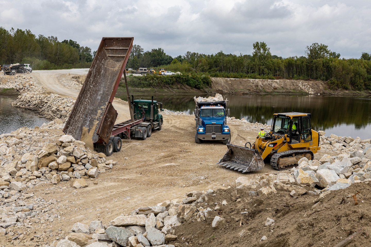 Truck drivers dumping rock.