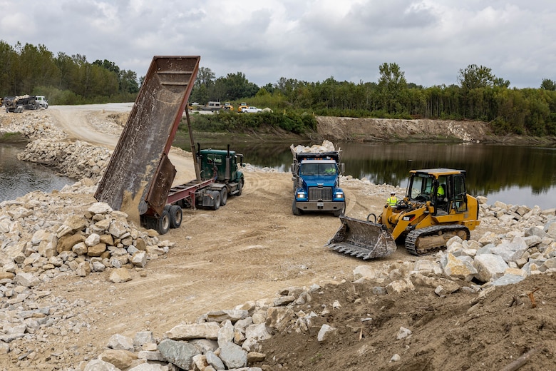 Truck drivers dumping rock.