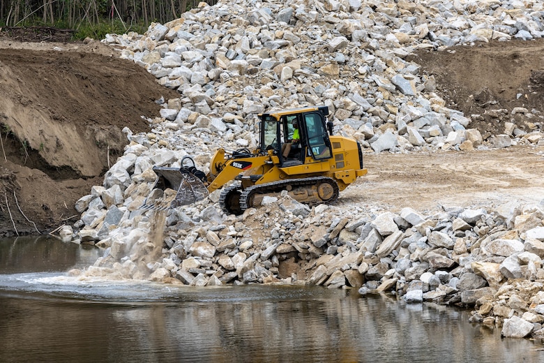 Heavy equipment operator placing rock.