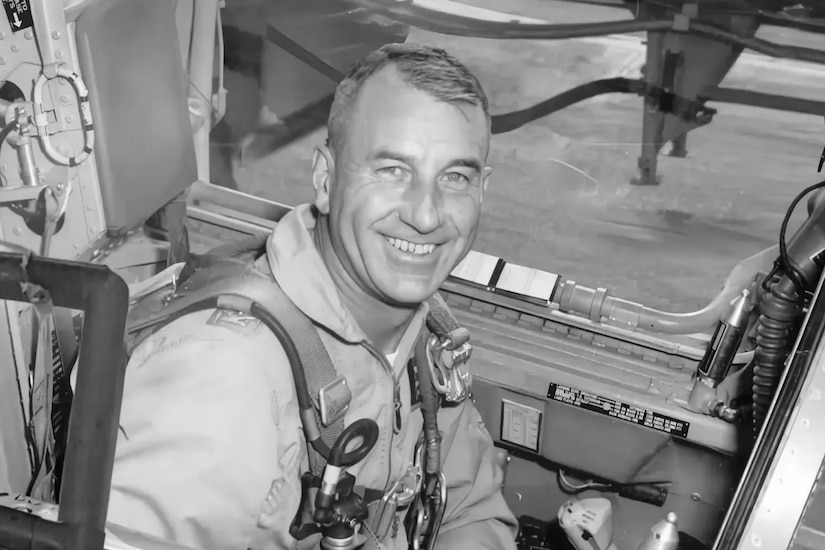 A man in an aircraft cockpit smiles for a photo.