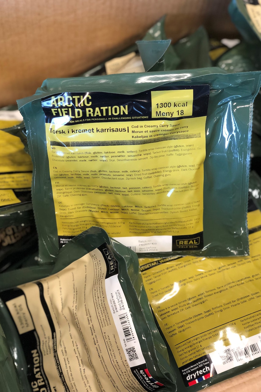 A box is filled with plastic-wrapped food rations with labels that read, "Arctic Field Ration."