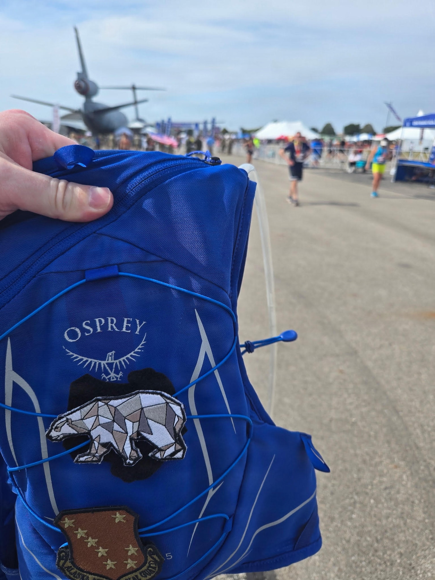 Master Sgt. Christopher Massengil, of the 168th Operations Group, holds up his running vest representing the 168th Wing Polar Bear patch at the 2025 Air Force Marathon.