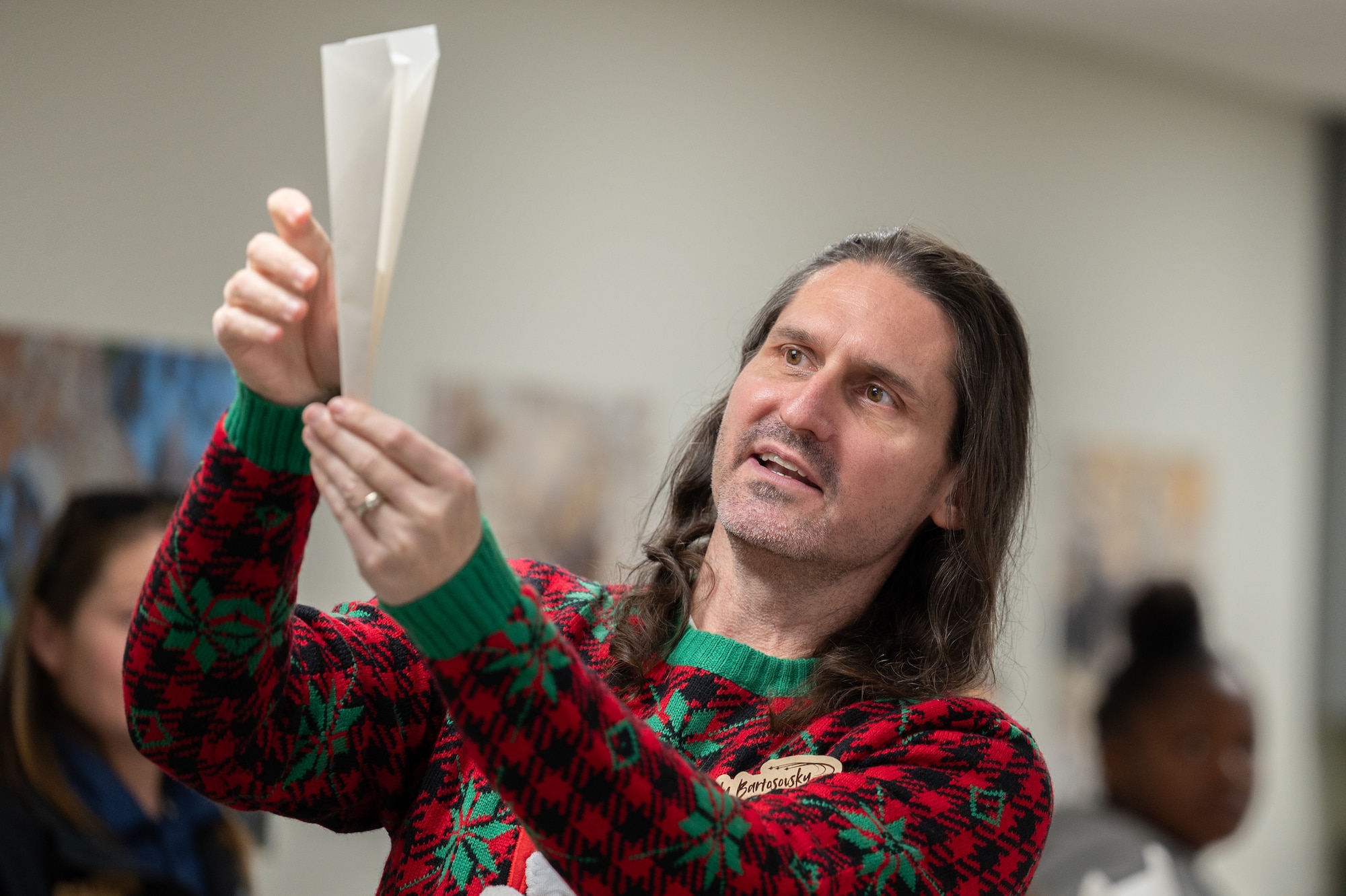 Andy Bartosovsky, Air Force Test Center Manpower and Organizations Division chief, demonstrates how to fold a paper airplane