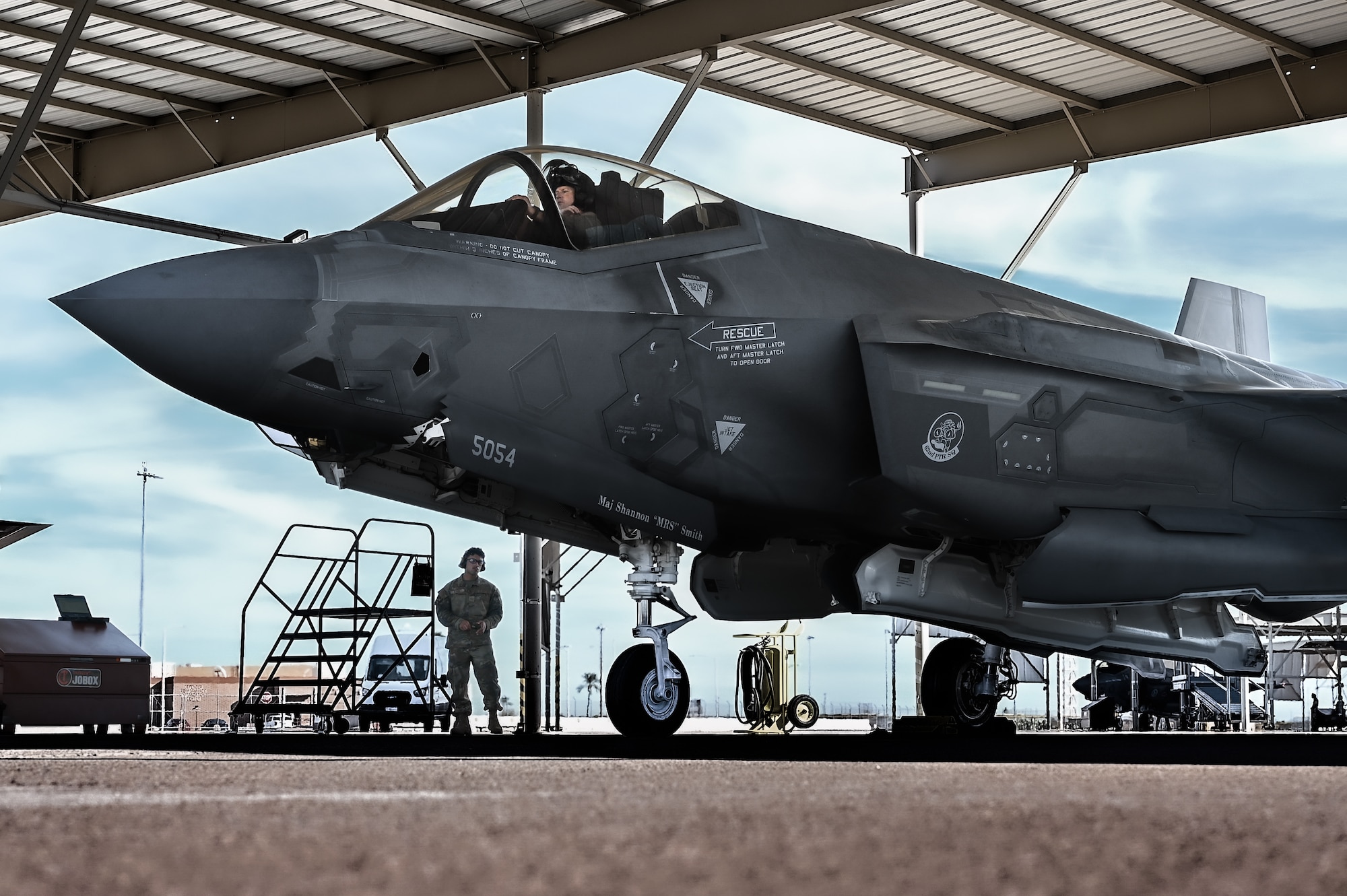 U.S. Air Force Brig. Gen. David Berkland, 56th Fighter Wing commander, secures his helmet in the cockpit of an F-35A Lightning II