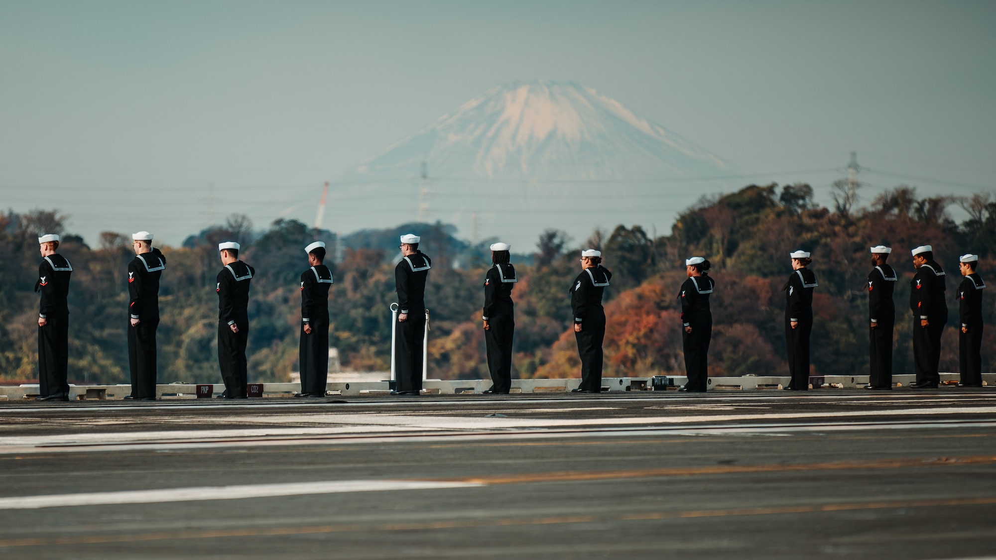 Sailors man the rails on the flight deck as Nimitz-class aircraft carrier USS George Washington (CVN 73) returns to Commander, Fleet Activities Yokosuka, Dec. 11, 2025. George Washington is U.S. 7th Fleet’s premier forward-deployed aircraft carrier, a long-standing symbol of the United States’ commitment to maintaining a free and open Indo-Pacific region, while operating alongside Allies and partners across the U.S. Navy’s largest numbered fleet. (U.S. Navy photo by Mass Communication Specialist 2nd Class Tyler Crowley)