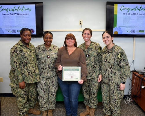 Registered Nurse Angela Williams, center, is pictured with her fellow Inpatient Mental Health employees at Naval Medical Center Camp Lejeune on Nov. 24, 2025. Williams was awarded the DAISY Award, a national recognition that honors nurses for their lasting impact on their patients. Williams was nominated by a patient's family for her "deeply human approach to care." NMCCL has provided more than 80 years of dedicated, passionate care for warfighters and beneficiaries at Marine Corps Base Camp Lejeune.