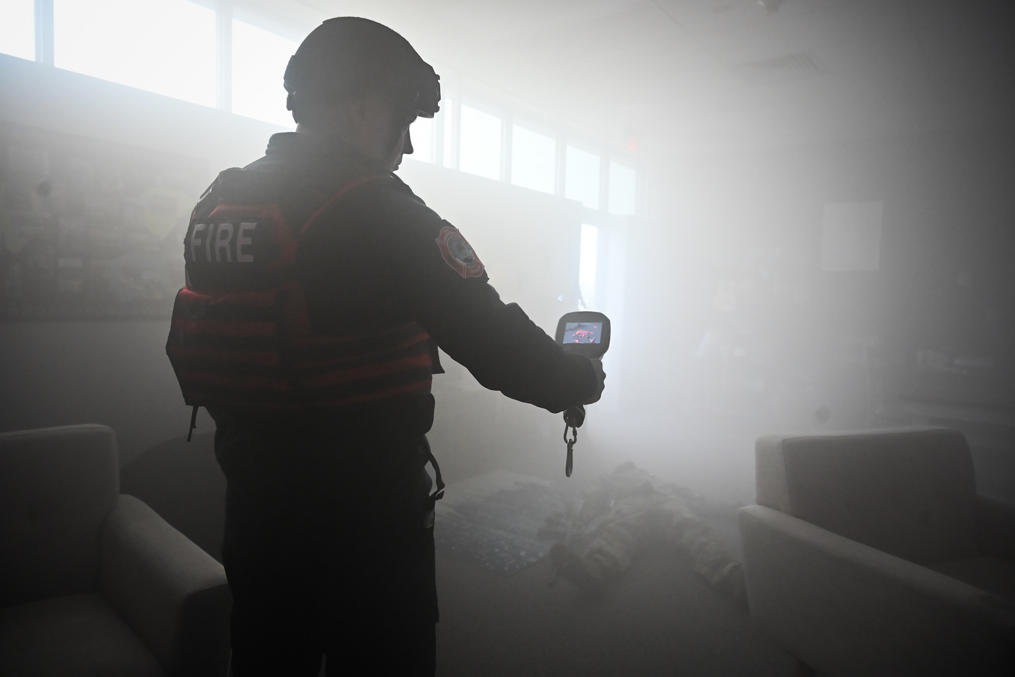 Fire fighter holds a thermal imaging camera.