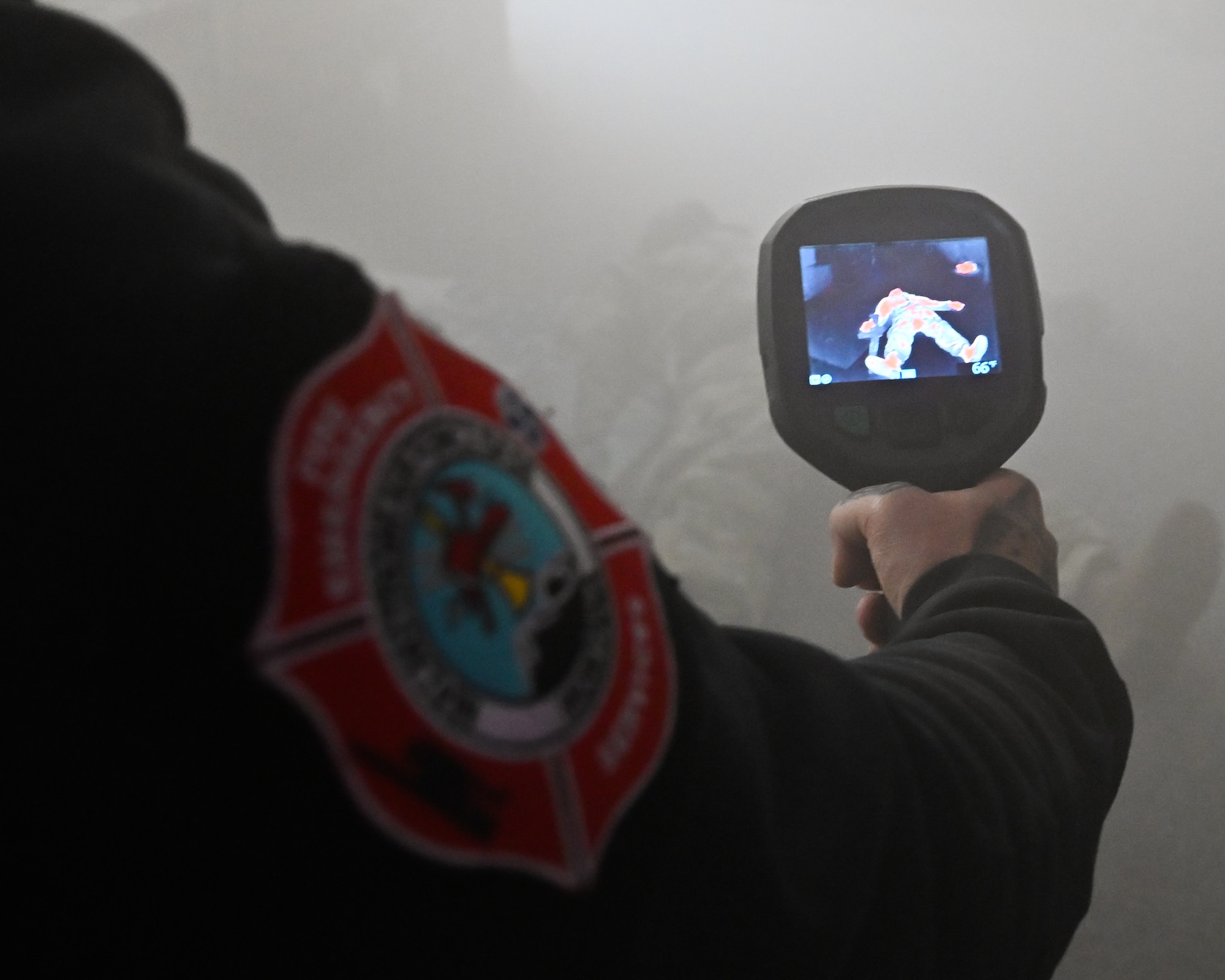 Fire fighter holds a thermal imaging camera.