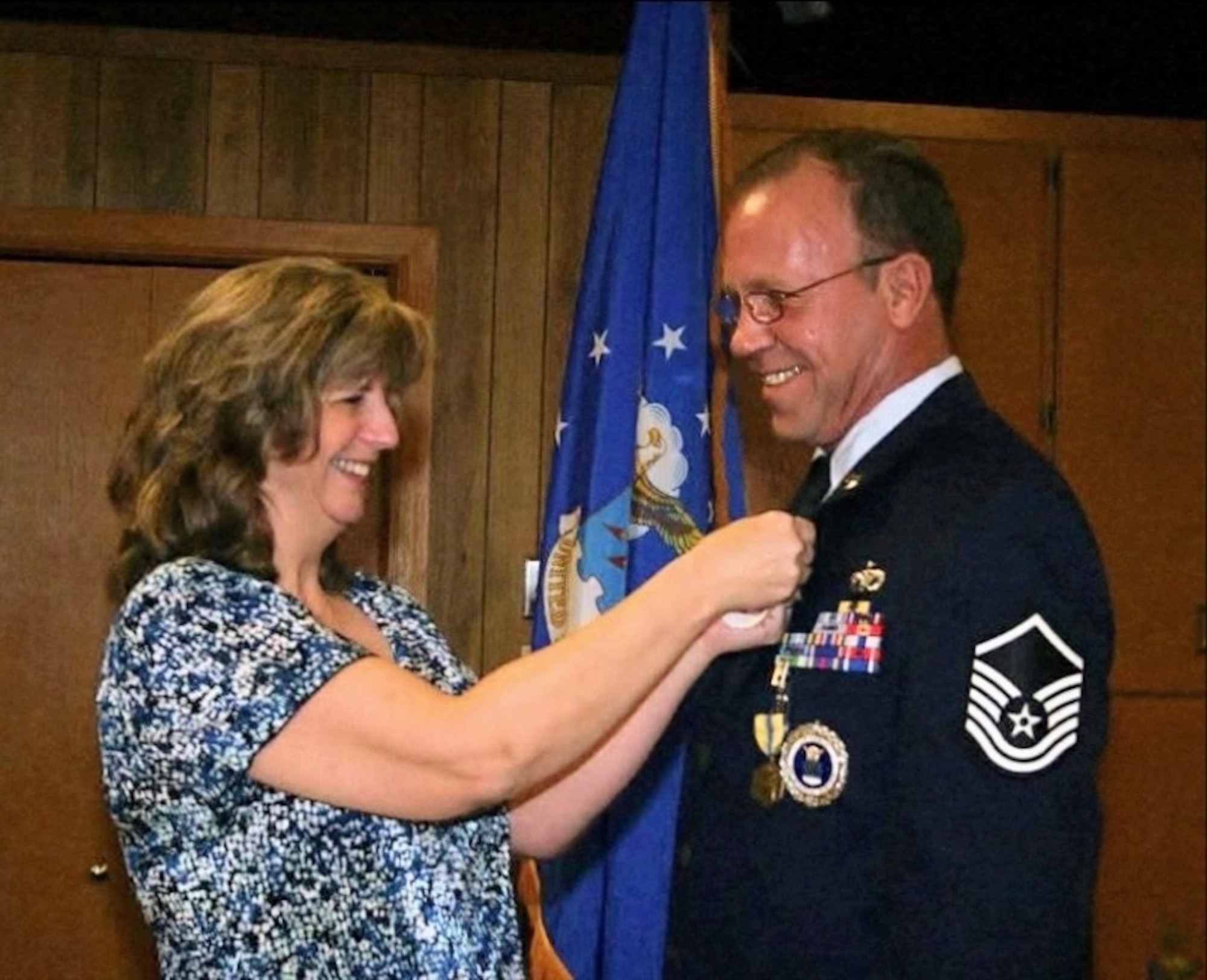 Patricia Casey dons the retirement pin on Thomas Casey in December 2012. Casey started his Air Force career in 1991 as a pavements and construction specialist and retired in 2012 as a military entrance processing station liaison in Minnesota before returning to active duty through the Voluntary Retired Return to Active Duty program in 2025. (courtesy photo)