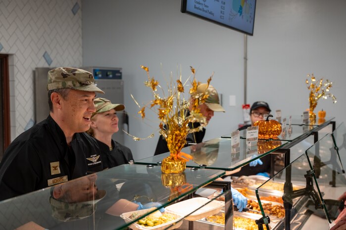 Four Airmen serve a Thanksgiving meal.