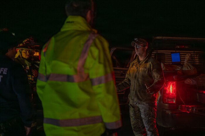 U.S. Air Force Staff Sgt. Bryce Schott, 9th Civil Engineer Squadron (CES) Explosive Ordnance Disposal (EOD) operations non-commissioned officer in charge, briefs local authorities on the disposal procedures for an Unexploded Ordnance (UXO) in Gualala, California, Dec. 9, 2025.