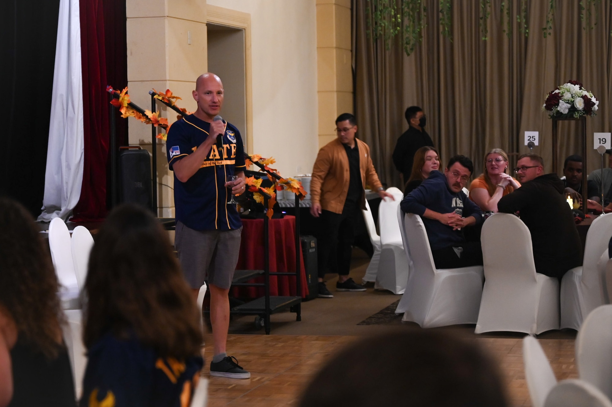 U.S. Air Force Airmen from the 11th Air Task Force sit in a row of chairs while participating in a holiday scavenger hunt during a Thanksgiving team party at Tumon, Guam, Nov. 27, 2025.