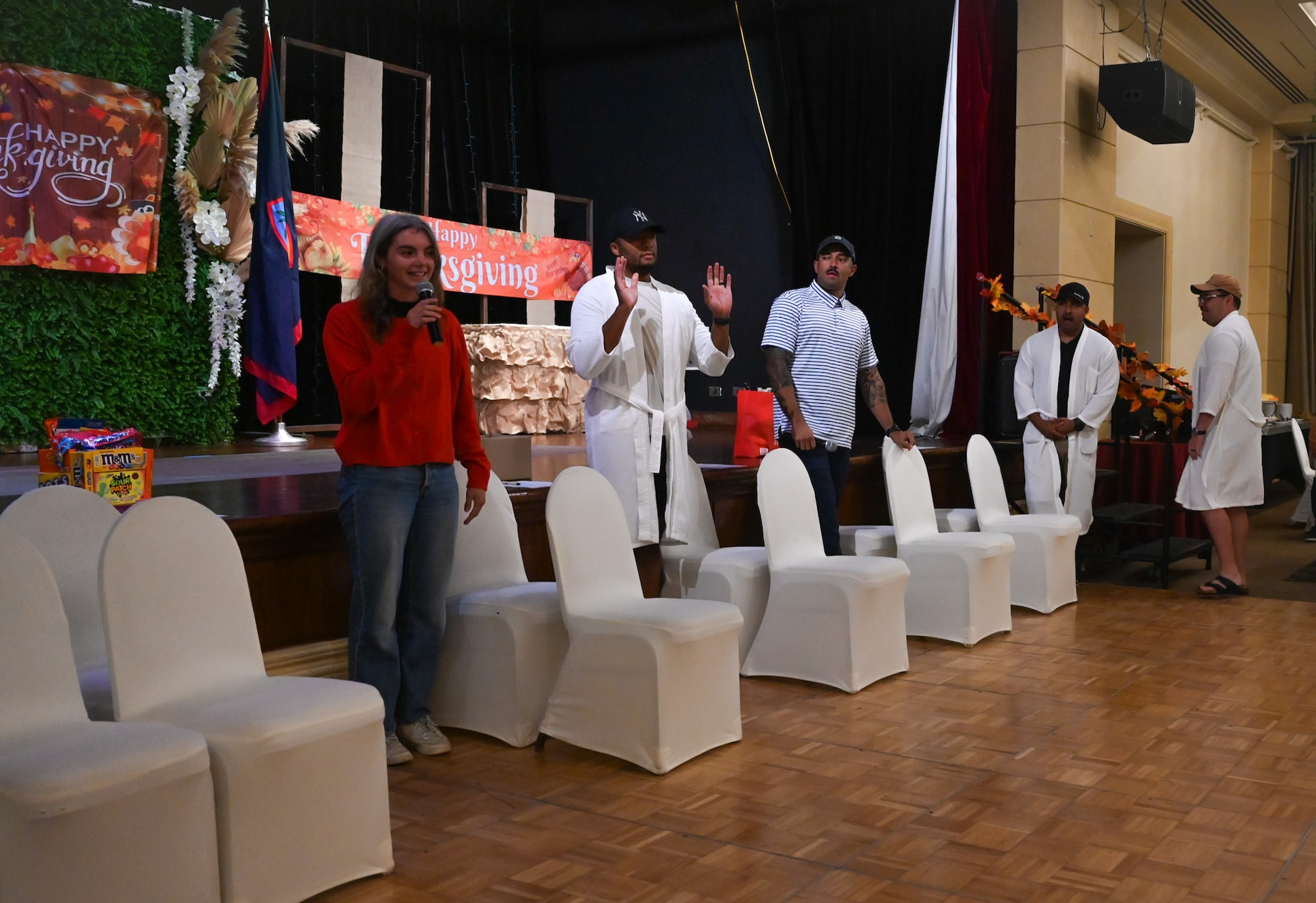 U.S. Air Force Airmen from the 11th Air Task Force sit in a row of chairs while participating in a holiday scavenger hunt during a Thanksgiving team party at Tumon, Guam, Nov. 27, 2025.