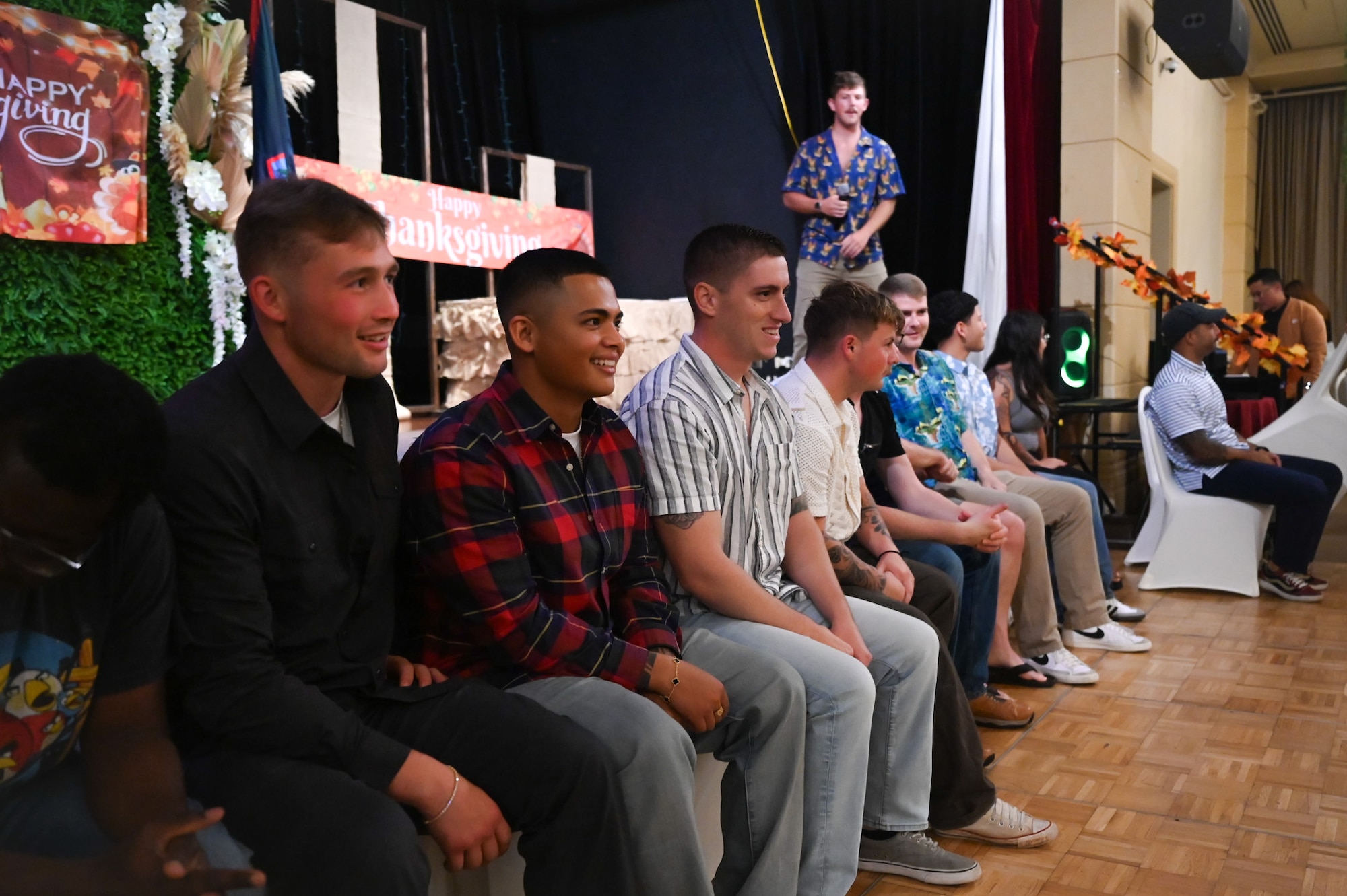 U.S. Air Force Airmen from the 11th Air Task Force sit in a row of chairs while participating in a holiday scavenger hunt during a Thanksgiving team party at Tumon, Guam, Nov. 27, 2025.