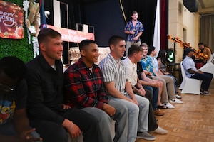 U.S. Air Force Airmen from the 11th Air Task Force sit in a row of chairs while participating in a holiday scavenger hunt during a Thanksgiving team party at Tumon, Guam, Nov. 27, 2025.