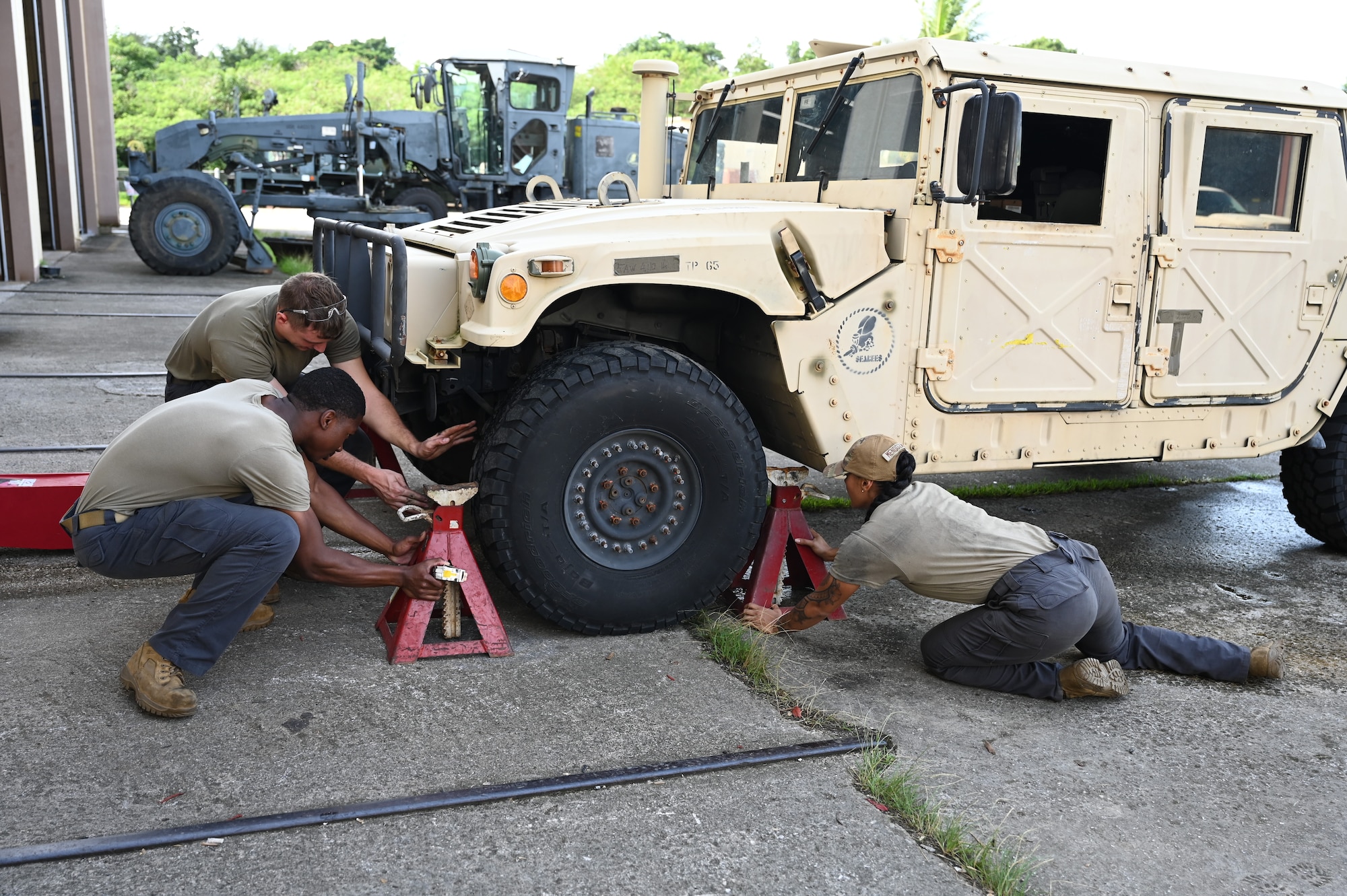 U.S. Air Force Airmen with the 11th Combat Air Base Squadron vehicle maintenance team pose with the Naval Mobile Construction Battalion, also known as the Seabees, after completing projects together at U.S. Naval Base Guam, Dec. 1, 2025.