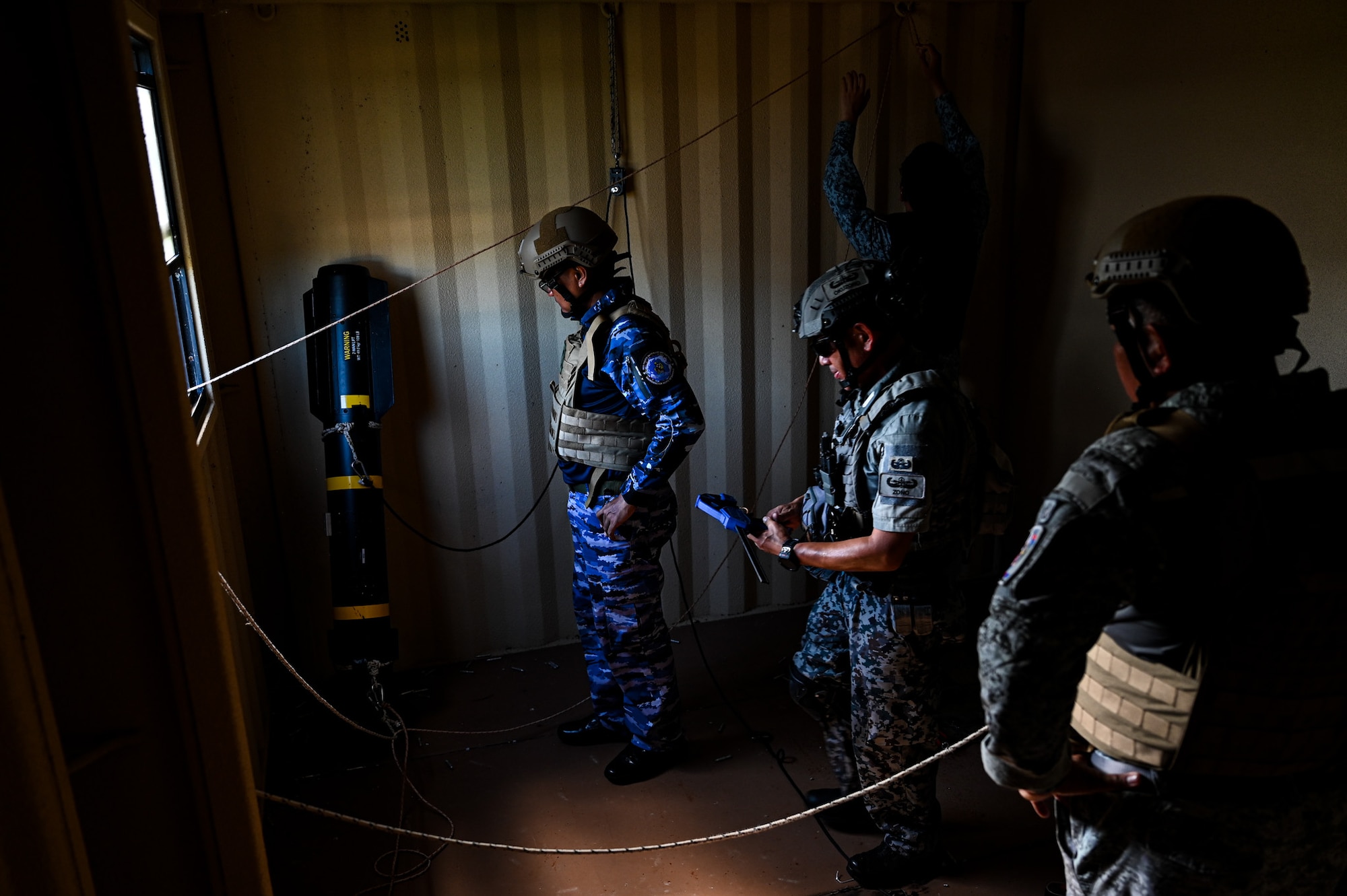 A combined team with members from the 11th Combat Air Base Squadron, other U.S. military units, Japan, Indonesia, the Philippines and Singapore establish a lever and pulley system to remove a simulated Hellfire missile from a building during exercise Silver Flag at Andersen Air Force Base, Guam, Sept. 25, 2025.