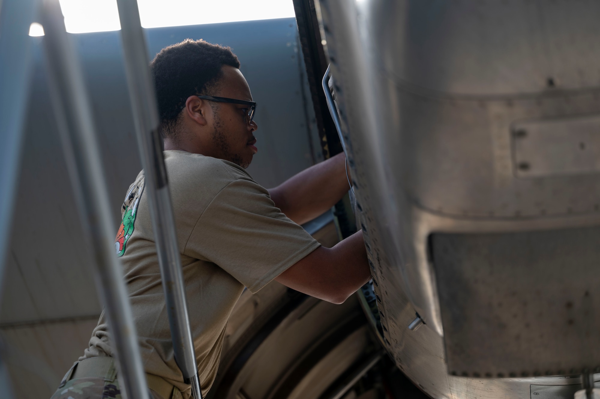 A military member conducts maintenance work on a C-130J aircraft.