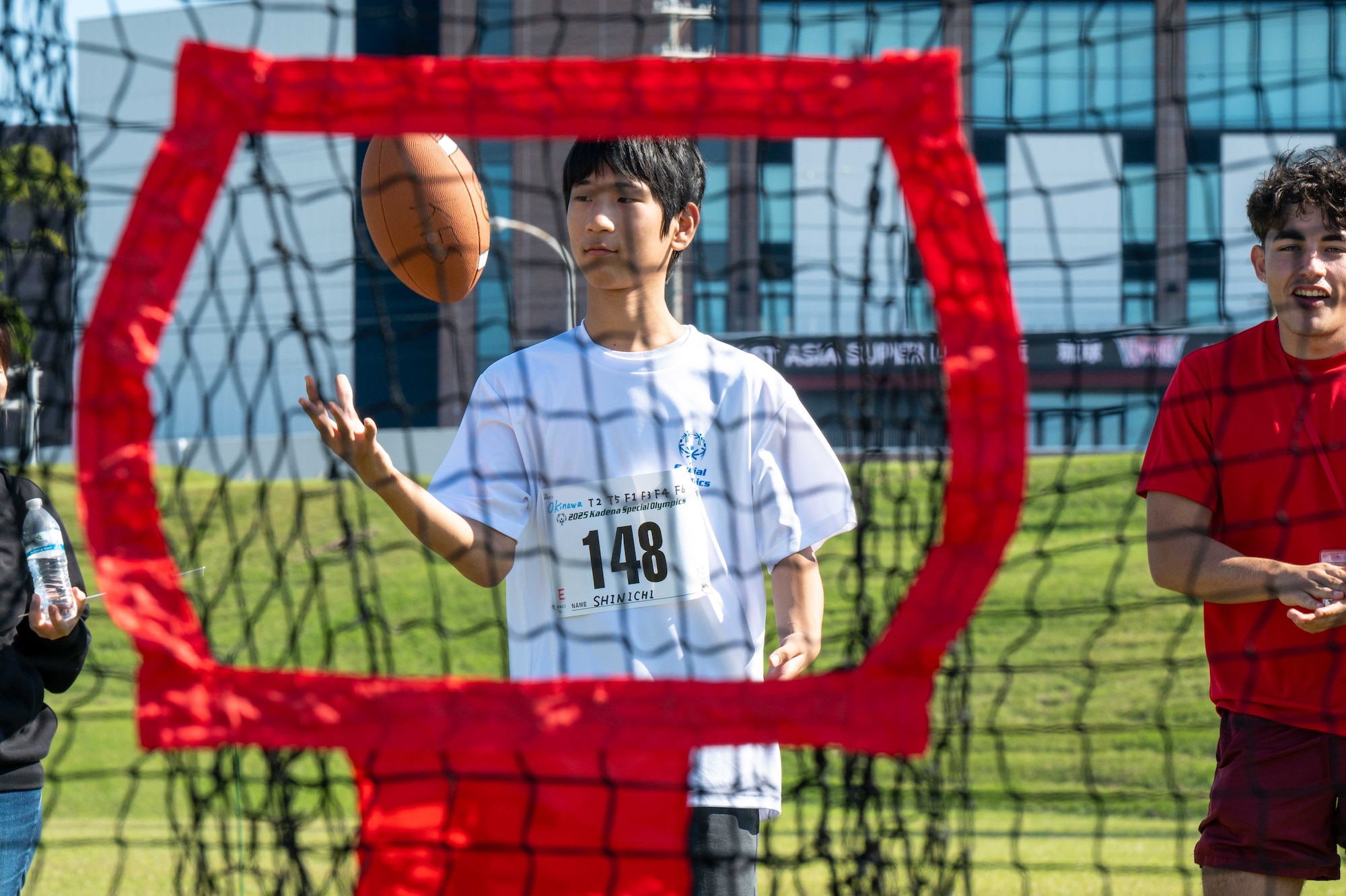 A Kadena Special Olympics athlete juggles a football during a quarterback throw event at Kadena Air Base, Japan, Dec. 6, 2025. KSO is a one-day sporting and entertainment event bringing competition and recognition to Okinawan and American Special Olympics athletes. (U.S. Air Force photo by Airman 1st Class Arnet Tamayo)