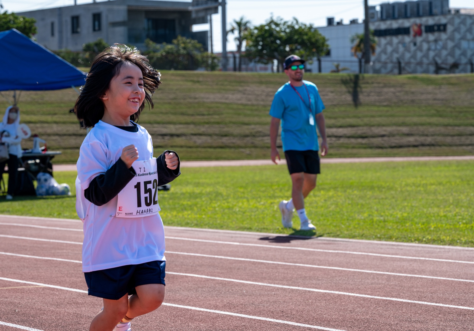 A Kadena Special Olympics athlete competes in the 50 meter dash event during the Kadena Special Olympics at Kadena Air Base, Japan, Dec. 6, 2025.  This year 104 athletes that registered, 14 American and 91 local contestants competed, all united in the endeavor to showcase the results of their diligent training.  (U.S. Air Force photo by Senior Airman Erin Currie)