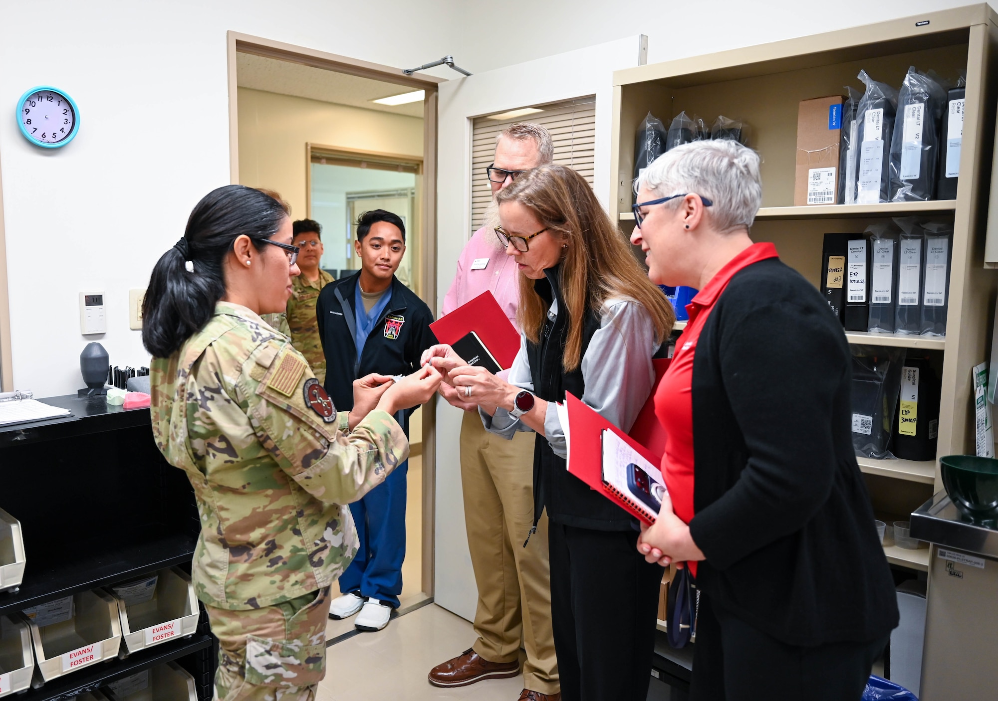 Service member shows dental mold to civilians.