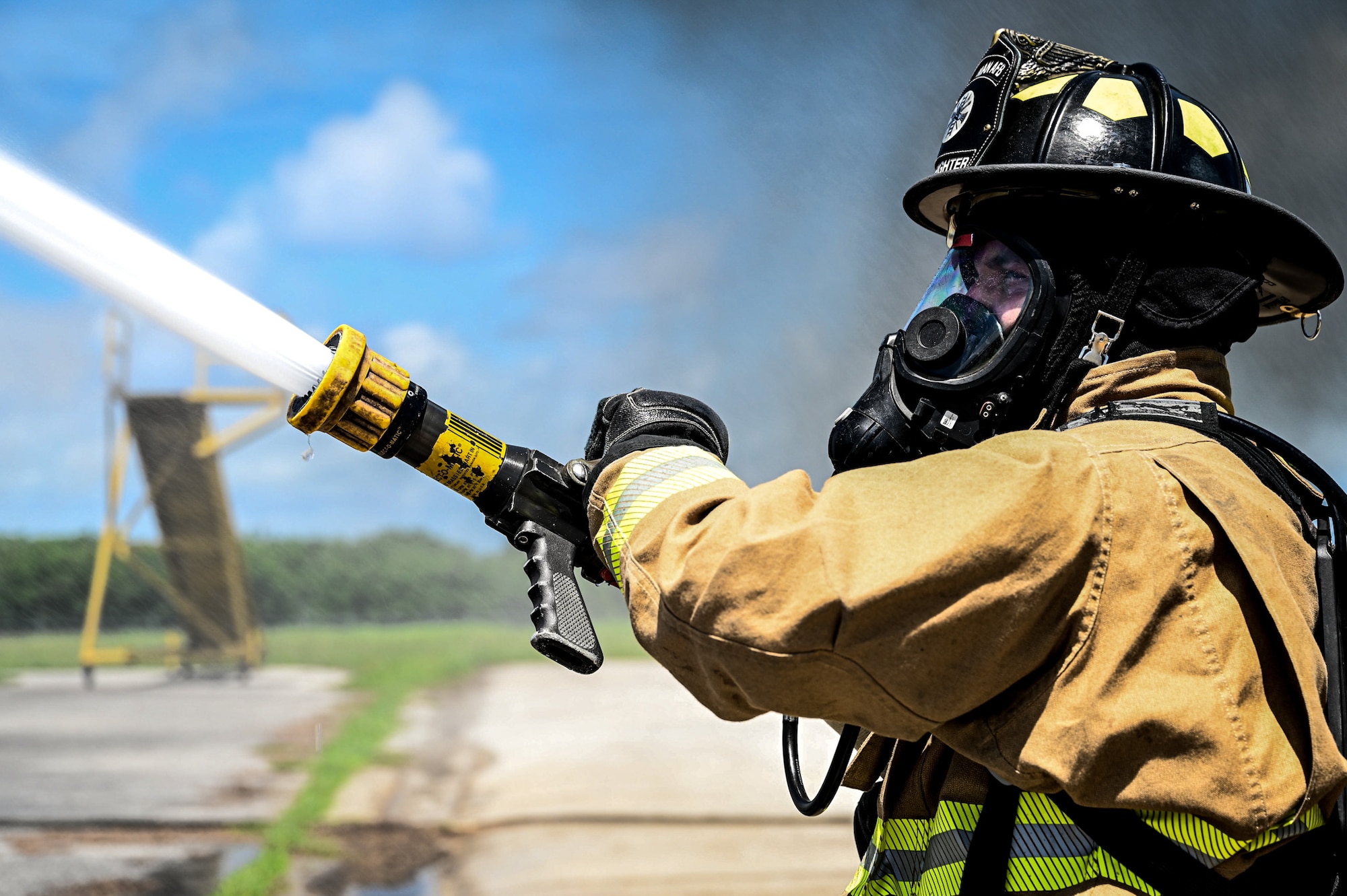 A U.S. Air Force Airman from the 11th Combat Air Base Squadron shoots water from a fire hose during a simulated aircraft fire during exercise Resolute Force Pacific in Saipan, Northern Mariana Islands, July 17, 2025.