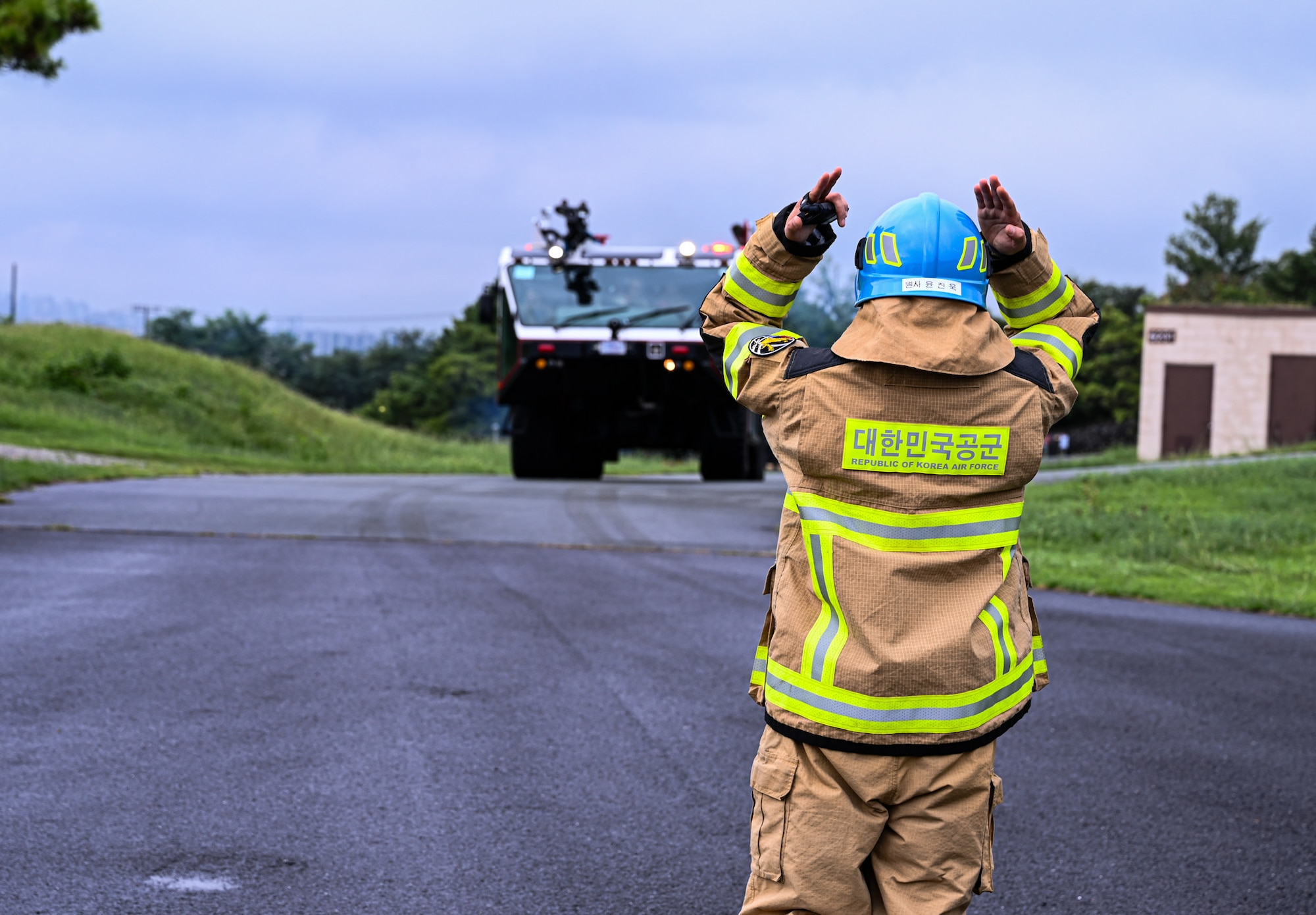 A member from the Republic of Korea air force directs a U.S. Air Force fire truck assigned to the 11th Combat Air Base Squadron down a road before integrated training begins at Daegu Air Base, Republic of Korea, Sept. 10, 2025.